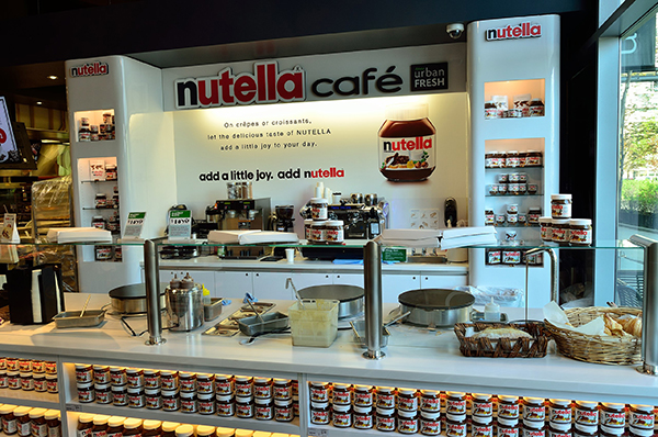 カナダの「Nutella Cafe」は、ヌテラをメインに使ったさまざまなスイーツや軽食を楽しめるカフェです。このカフェでは、パンケーキやワッフル、クレープ、トーストなどにNutellaがたっぷりトッピングされたメニューが提供されており、Nutellaファンにとって特別な体験ができる場所です。  Nutella Cafeの店舗は、店内が温かみのあるデザインで装飾されており、Nutellaの特徴的なジャーや色合いをインテリアに取り入れたユニークな雰囲気が特徴です。また、Nutellaを使用したオリジナルドリンクやテイクアウトのスナックもあり、友人や家族と楽しむことができるカジュアルでフレンドリーな場所として親しまれています。